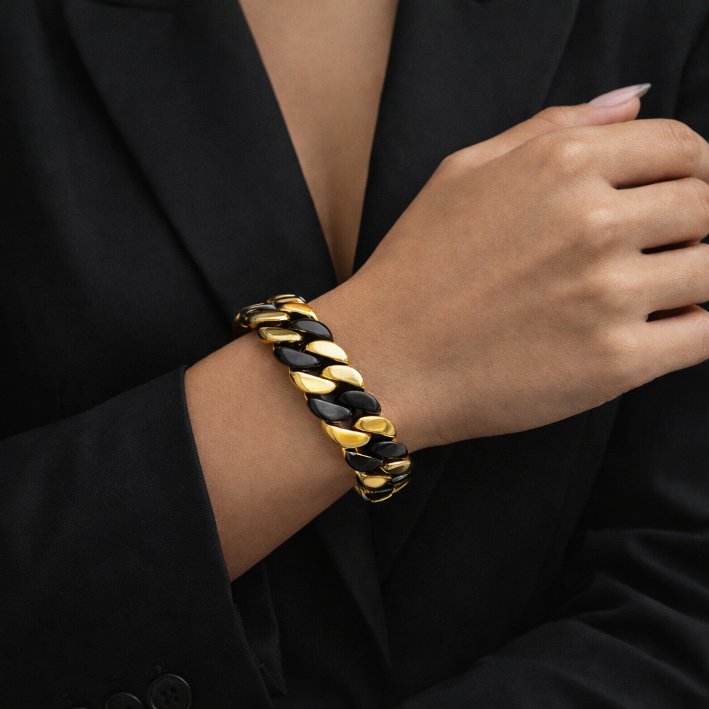 Black and gold flat Cuban link bracelet on a wrist